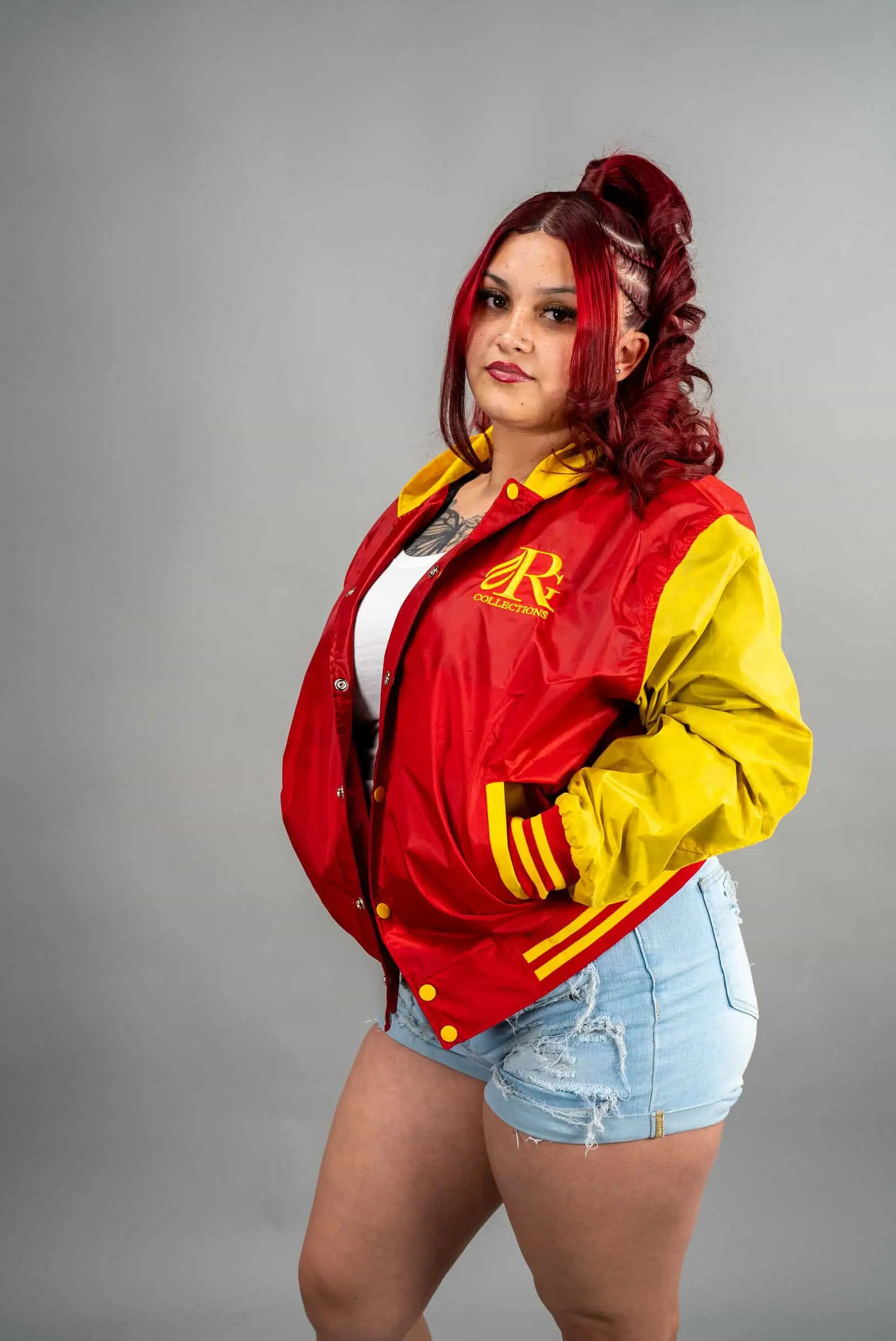 Reign Gear women's red and yellow water-repellent hooded varsity jacket.