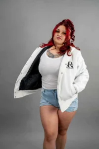 Woman with red hair wearing Reign Gear LLC jacket and casual outfit.