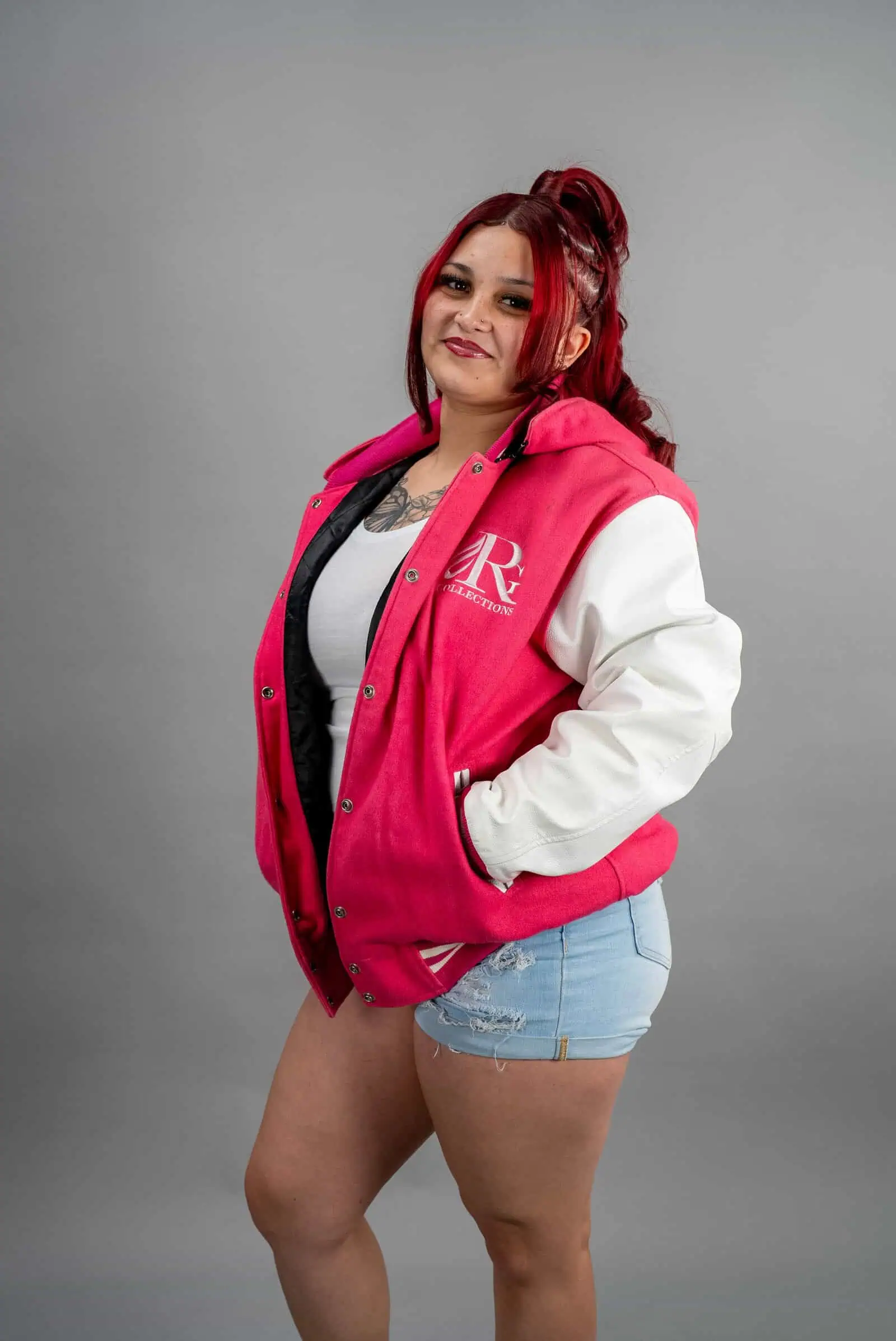 Reign Gear women's pink and white water-repellent zipper hooded varsity jacket.
