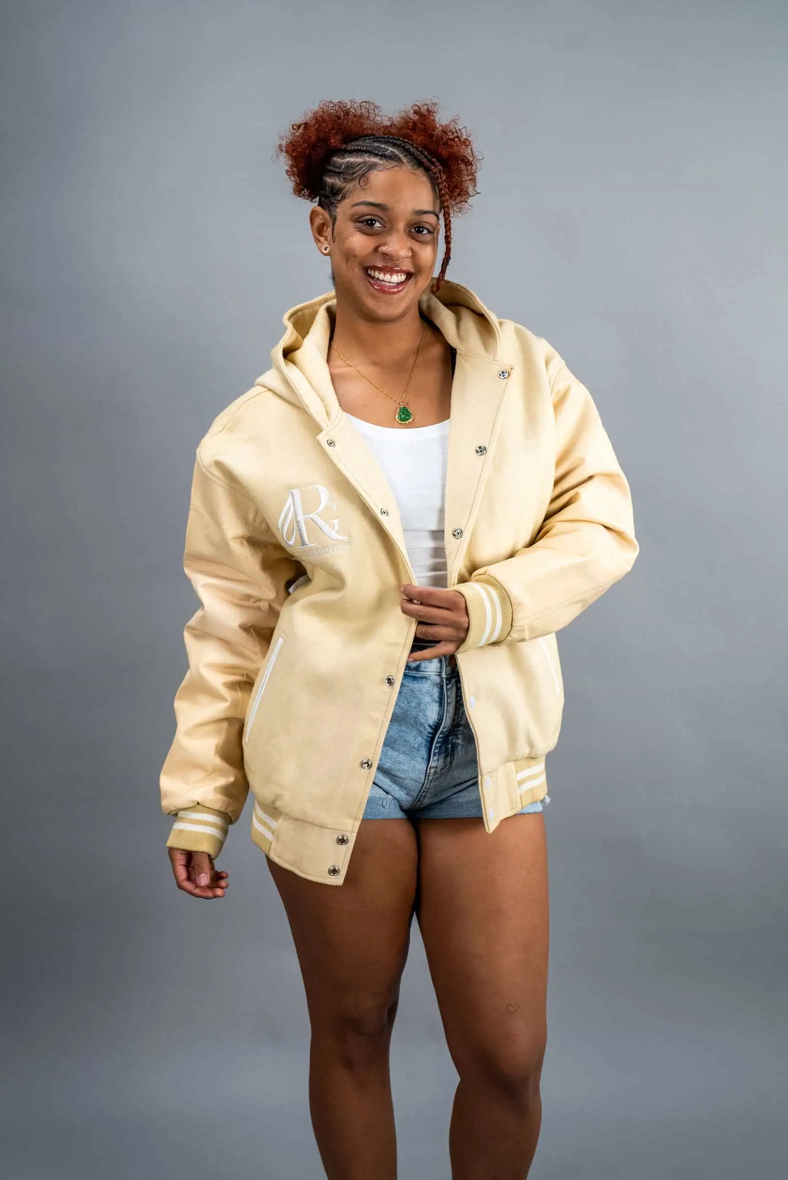 Reign Gear women's water-repellent hooded varsity jacket in cream.