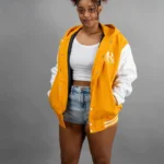 Reign Gear women's gold and white water-repellent hooded varsity jacket.
